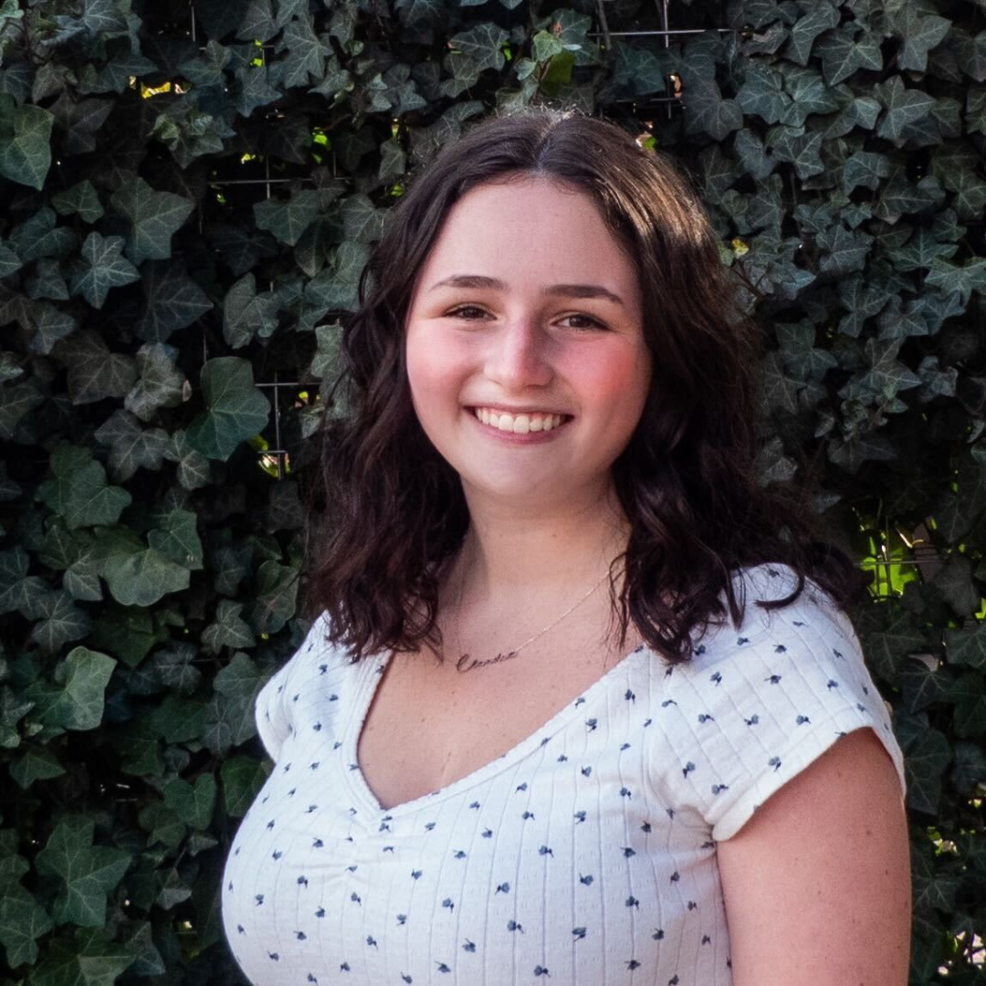 Claudia, a young white woman with dark brown hair and brown eyes