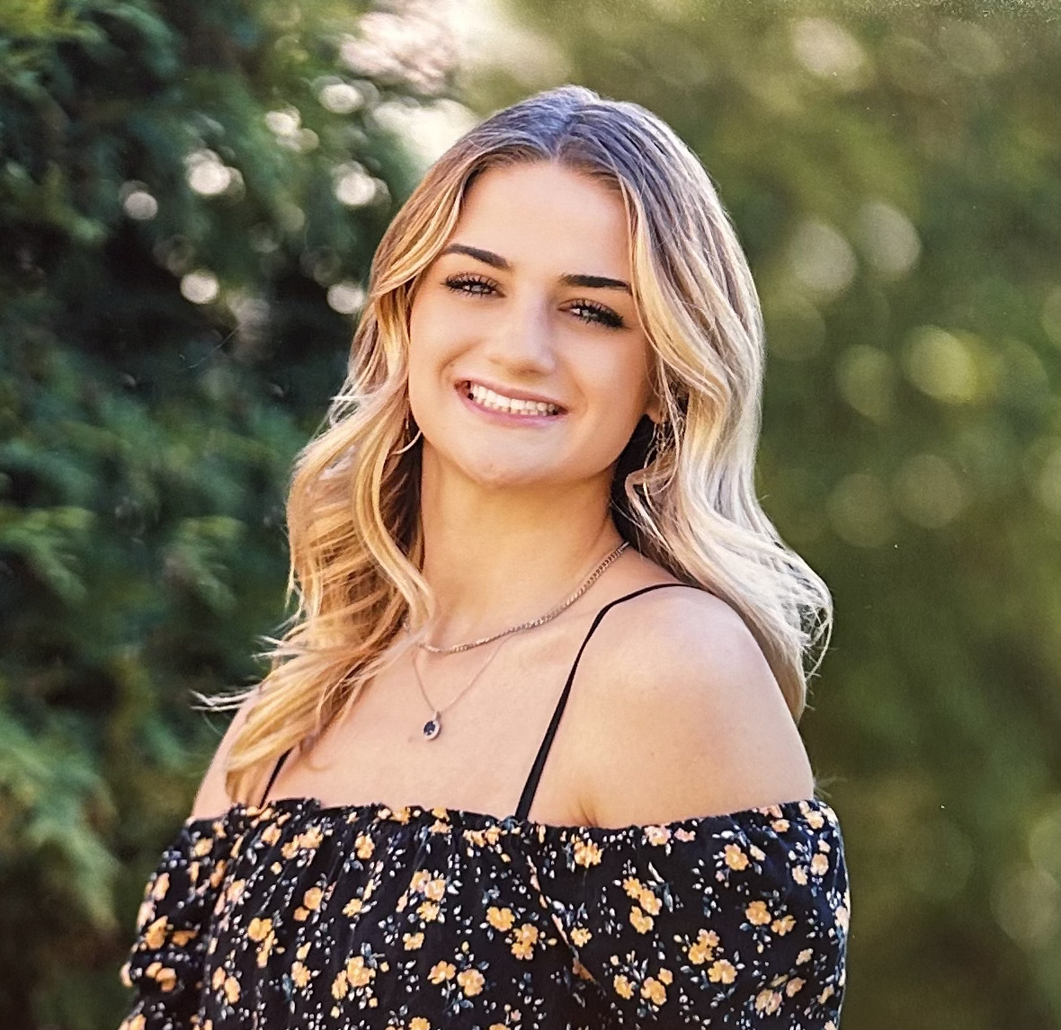 Eva, a young white woman with wavy blonde hair, smiles at the camera.