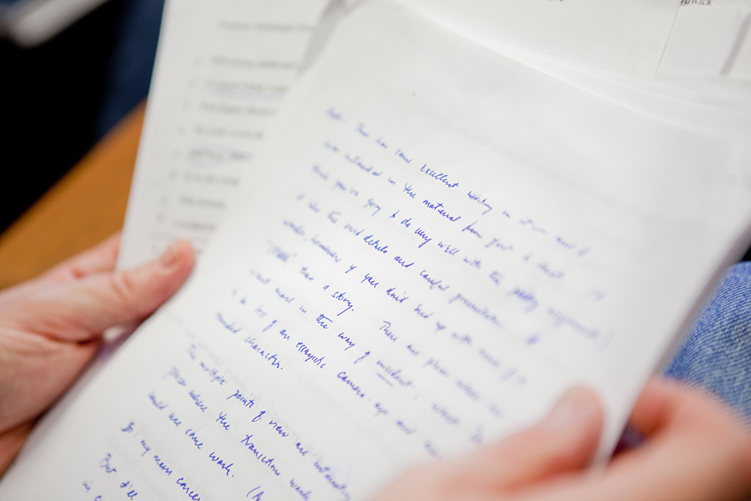 A hand holding up a stack of paper