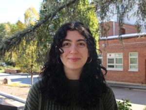 Mariam, young white woman with curly brown hair, smiling at the camera