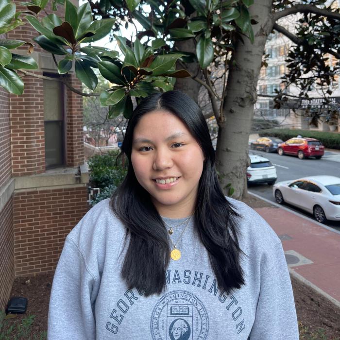 Andrea, a young Asian woman with dark black hair, smiles at the camera. 