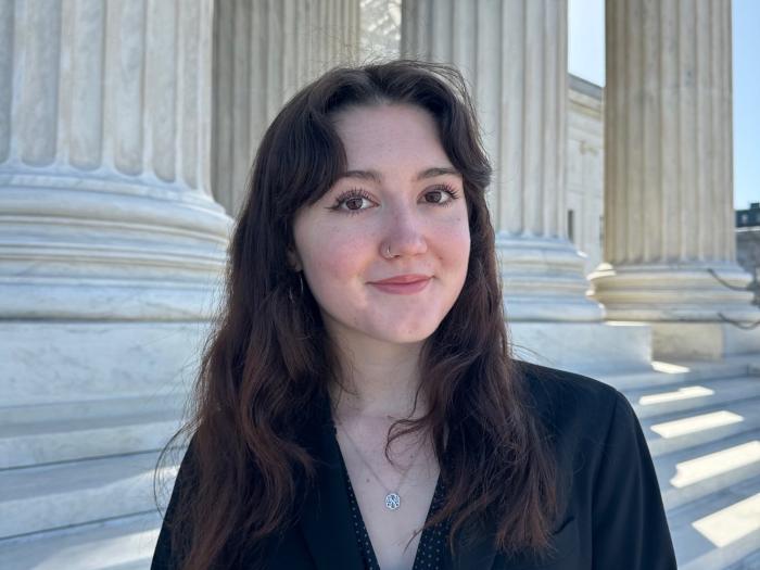 Grayson, a young white woman with wavy hair, smiles at the camera.
