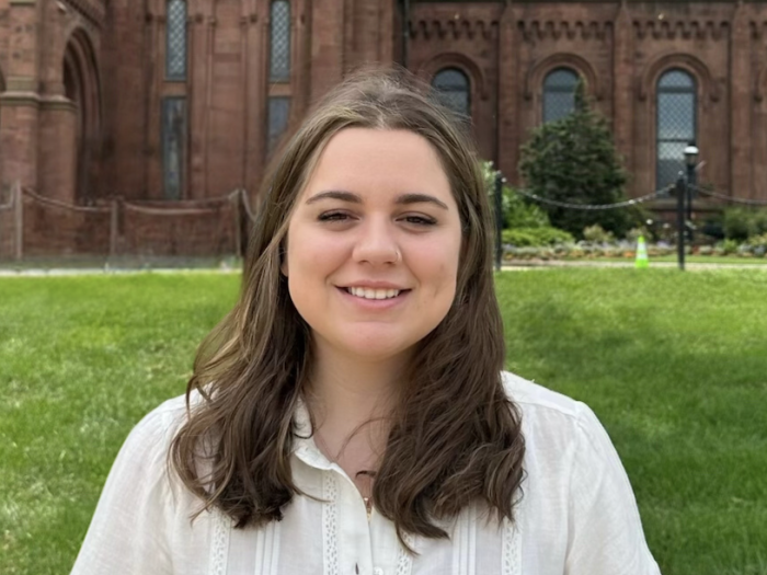 Hope, a young white woman with straight brown hair and brown eyes, smiling.