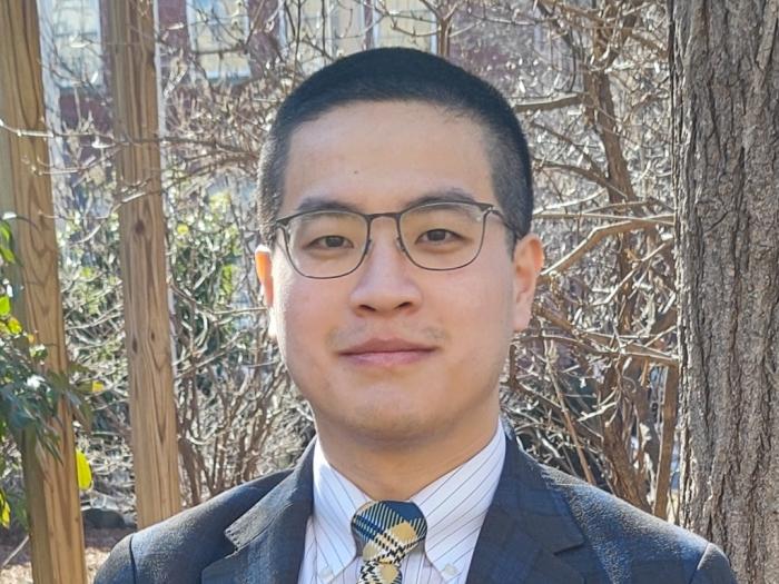 Nemo, a young man in glasses wearing a suit and tie.